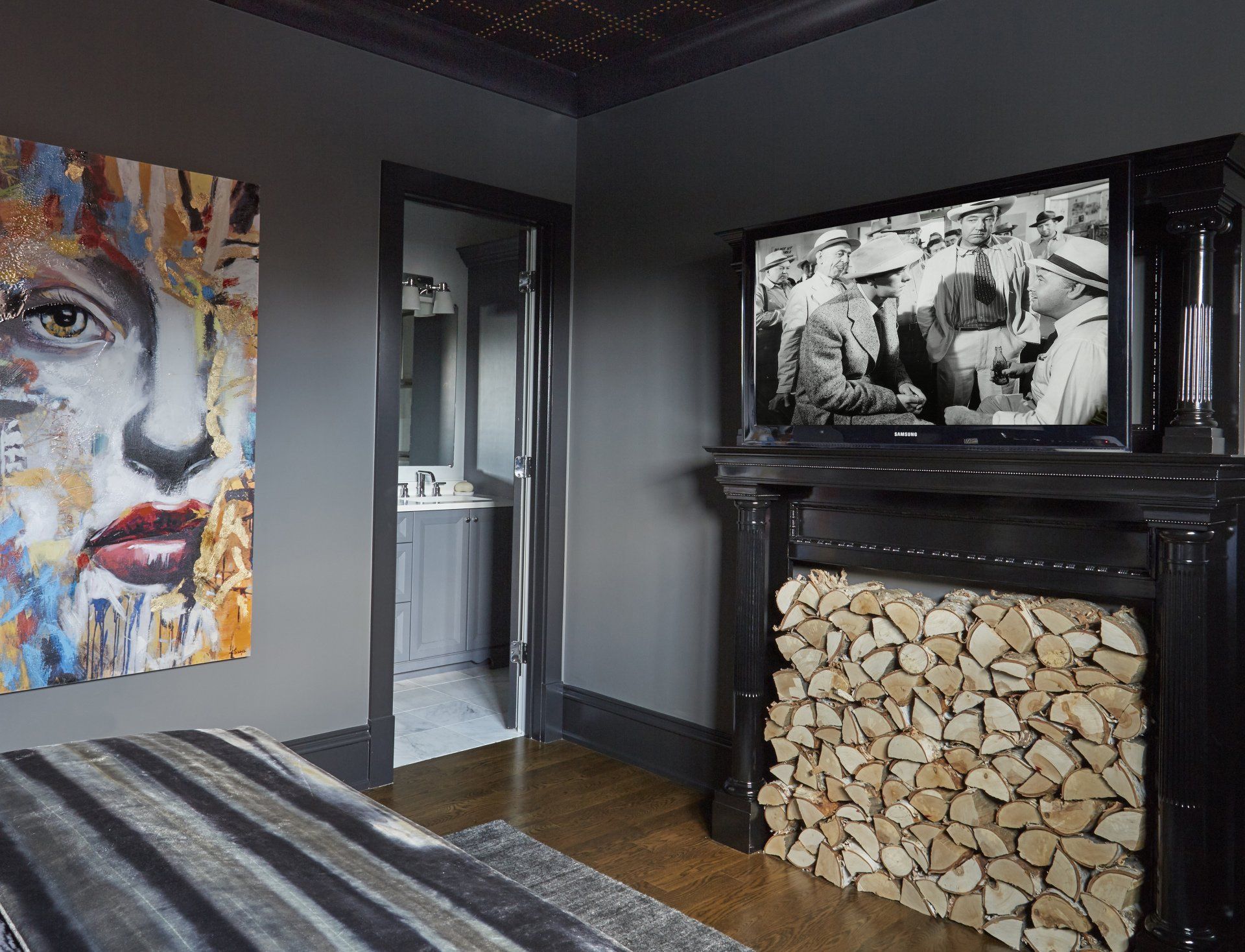 A bedroom with a fireplace and a flat screen tv