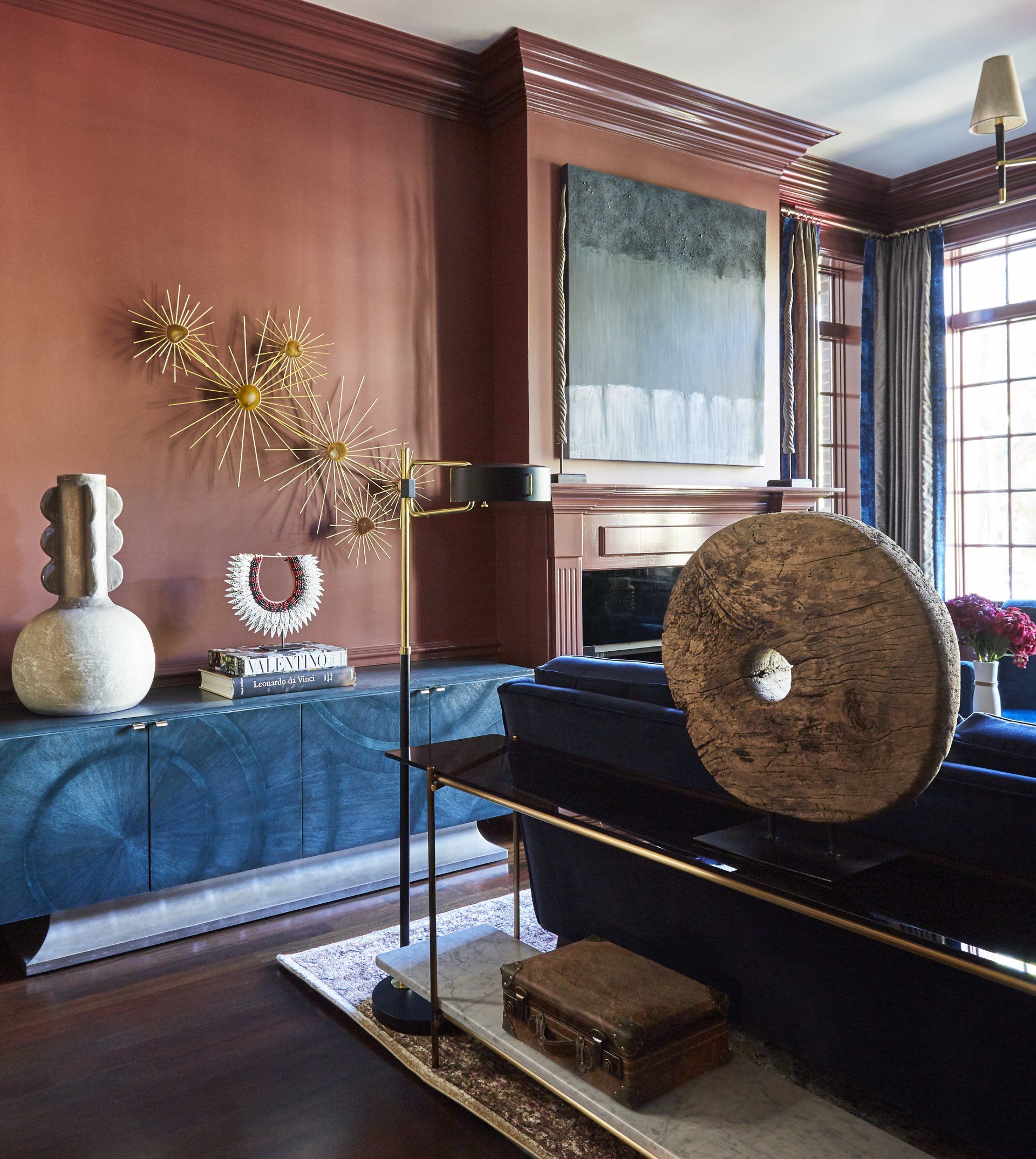 A living room with a blue couch and a painting on the wall