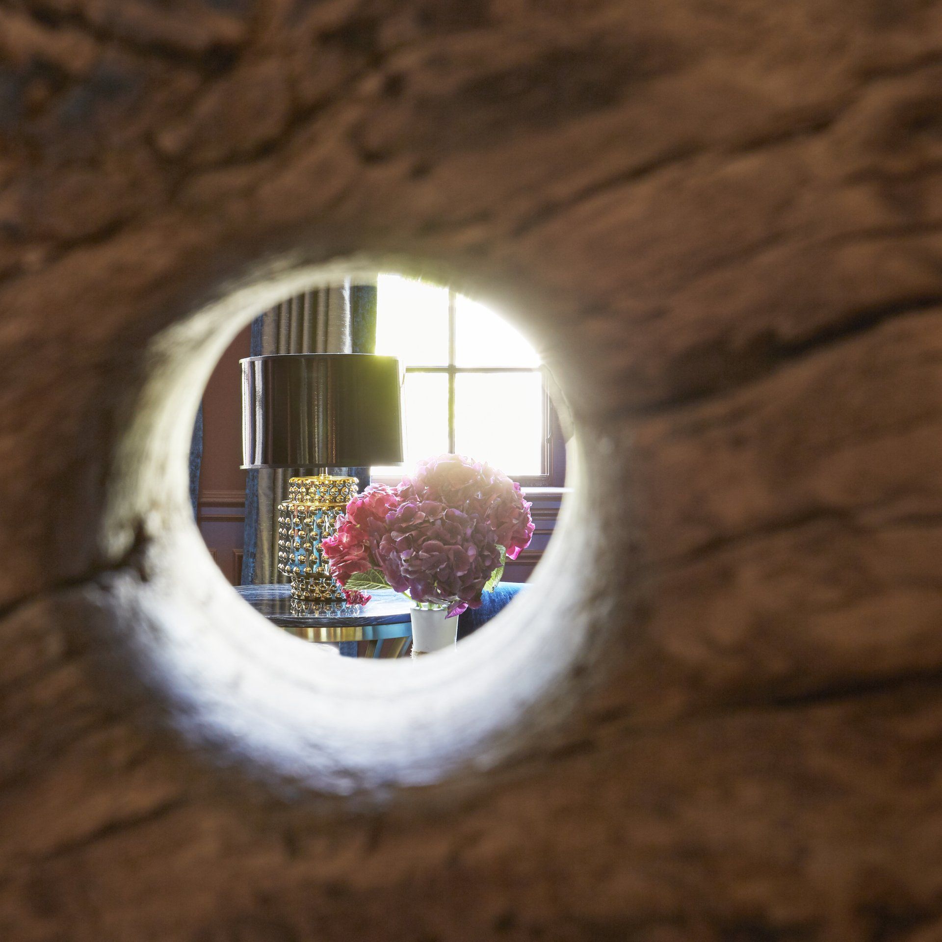 A view of a living room through a hole in a wall