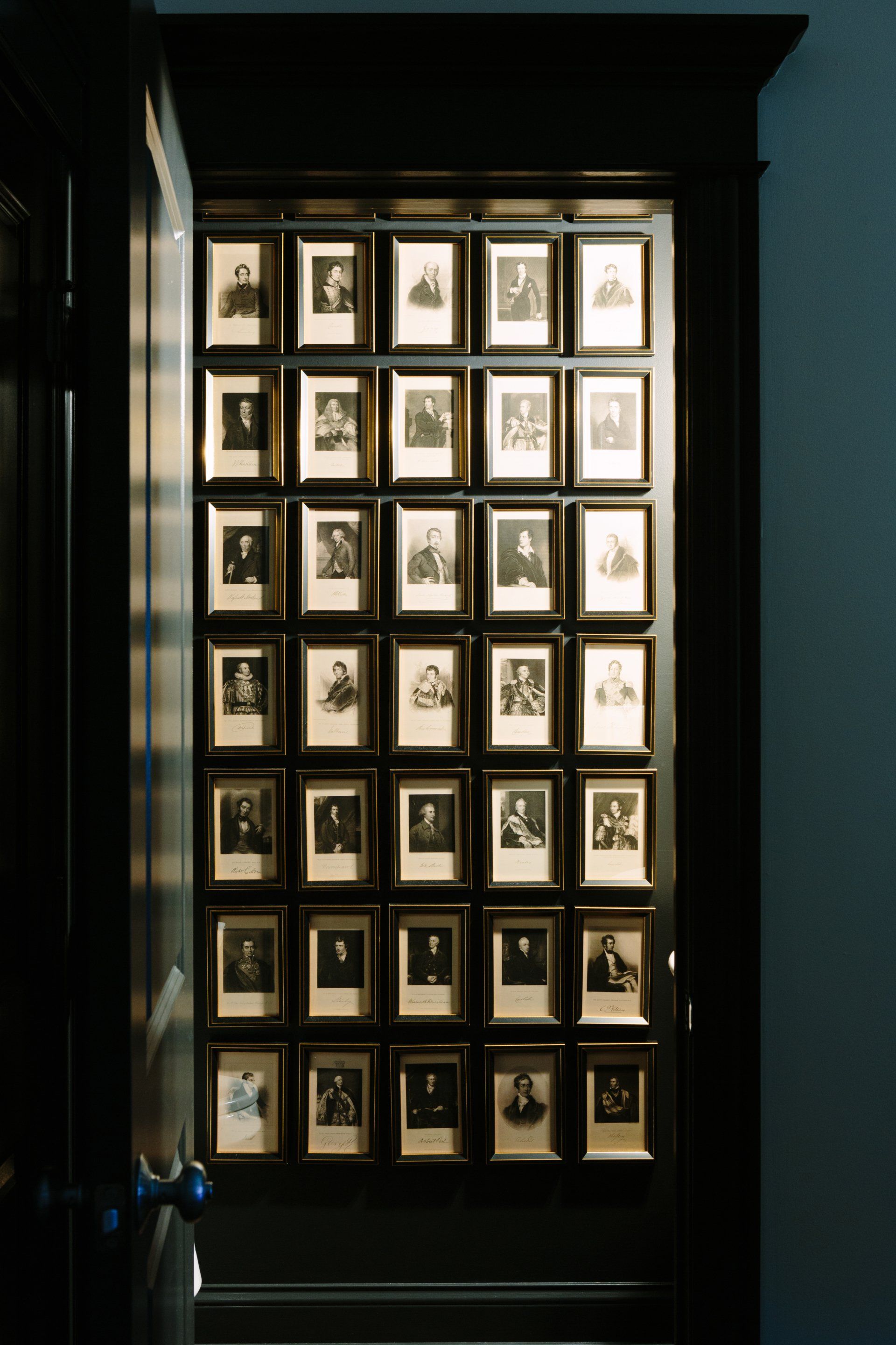 A cabinet filled with lots of pictures of people in frames.