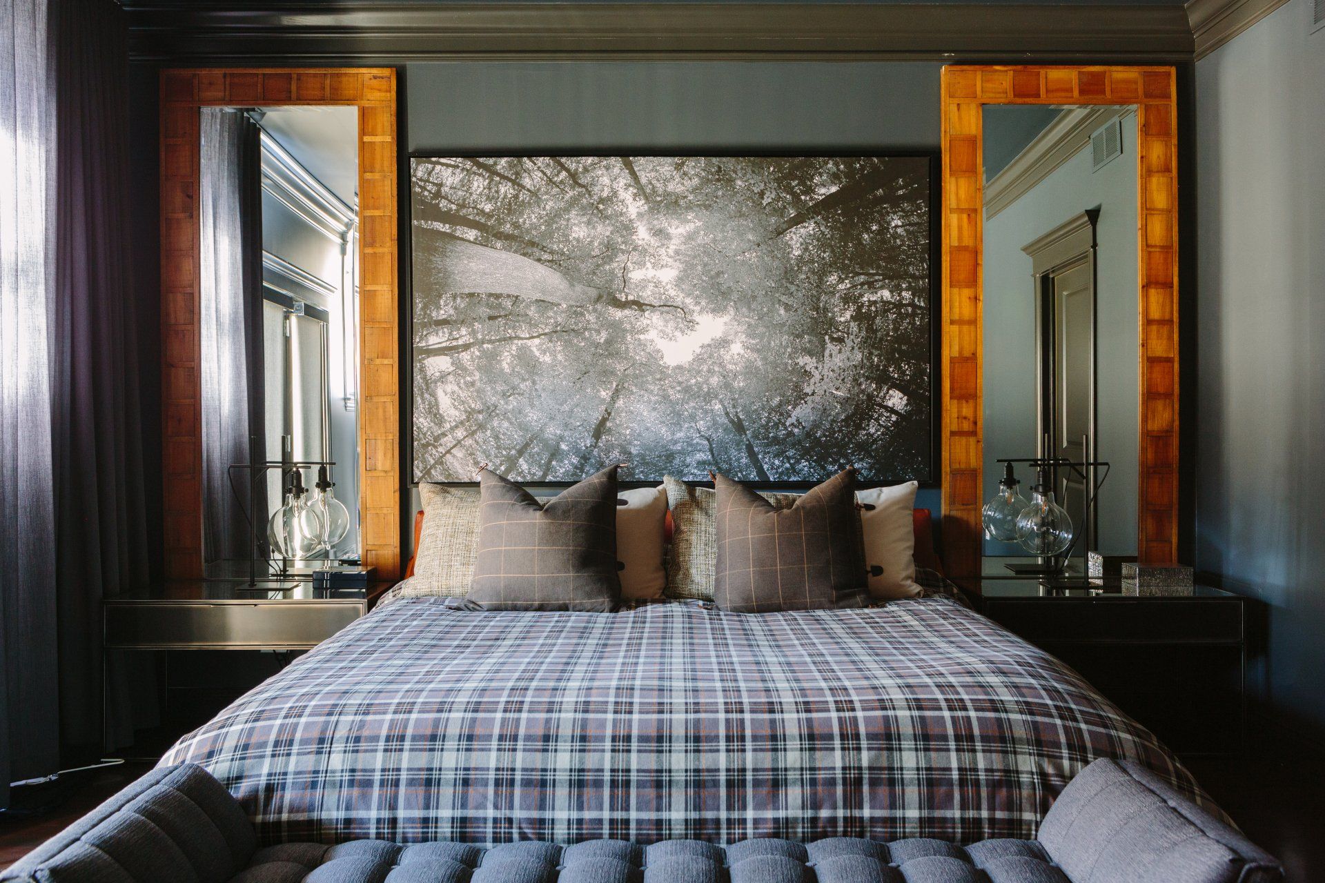 A bedroom with a large painting on the wall above the bed