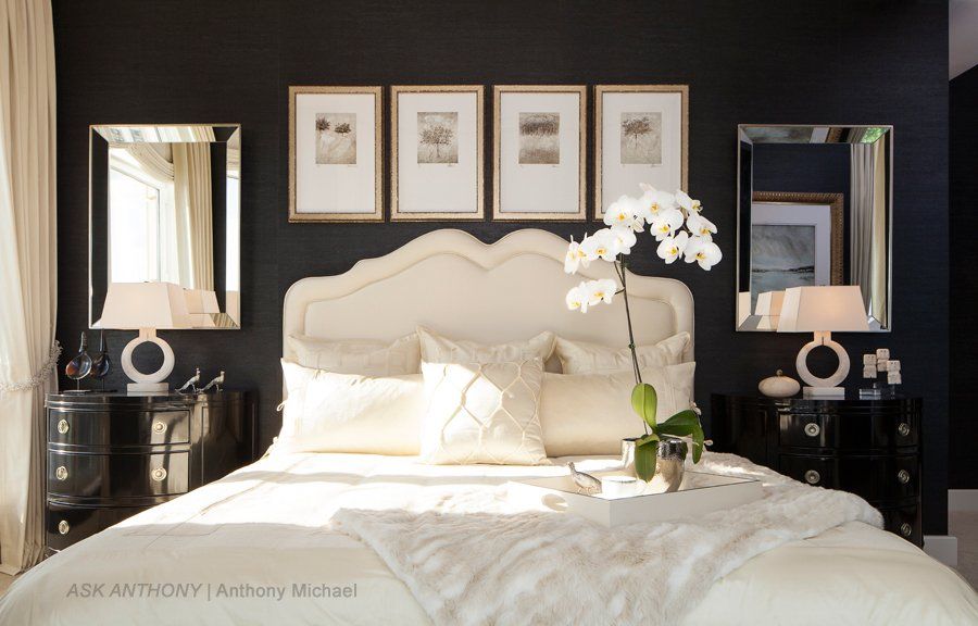 A bedroom with a bed and two mirrors on the wall
