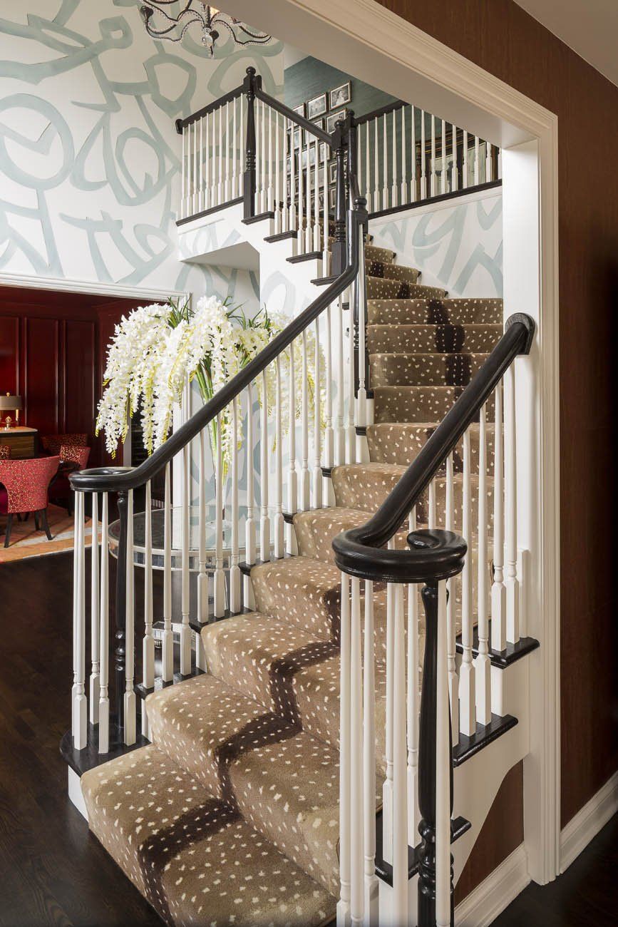 A staircase with a carpeted staircase and a black railing