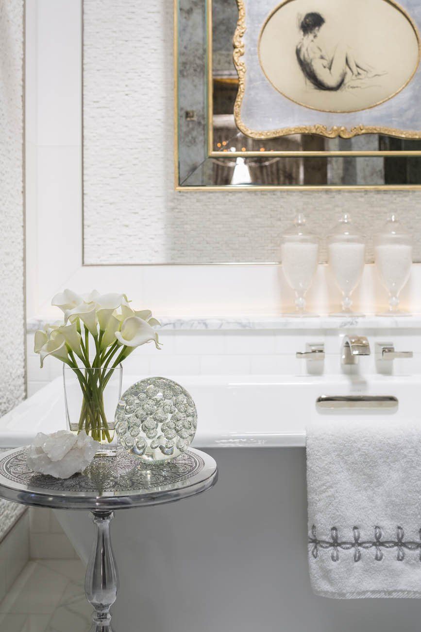 A bathroom with a tub , sink and mirror