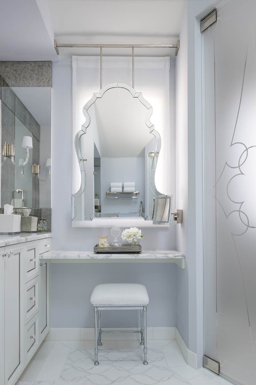 A bathroom with a vanity , mirror and stool.