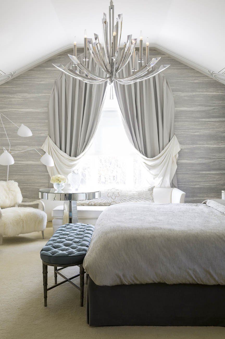 A bedroom with a large bed and a chandelier