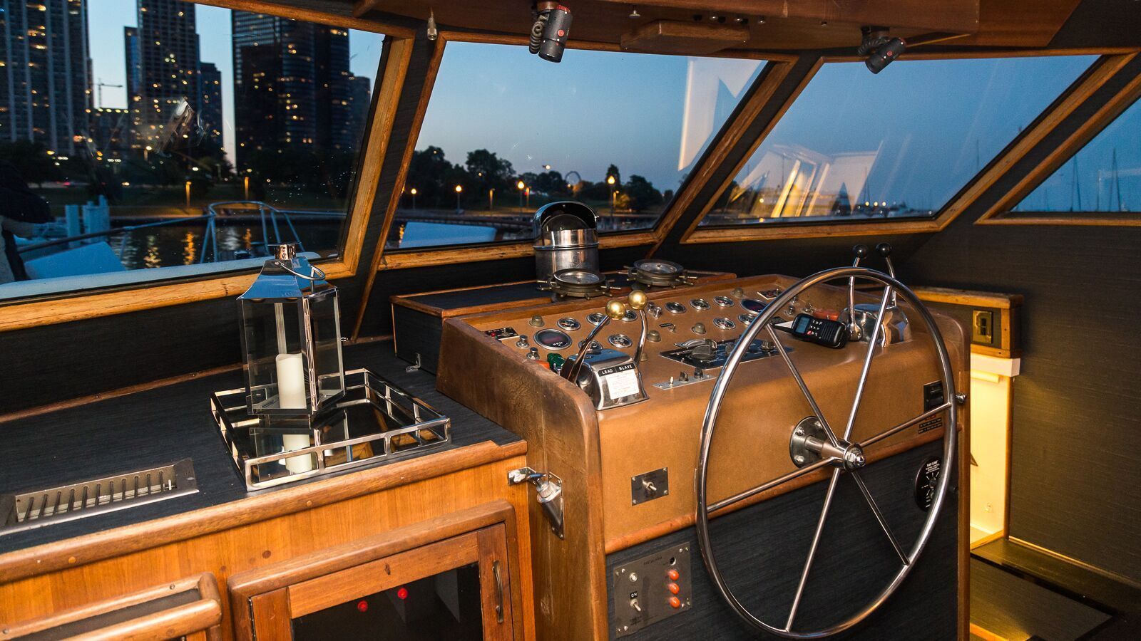 The inside of a boat with a steering wheel and controls.