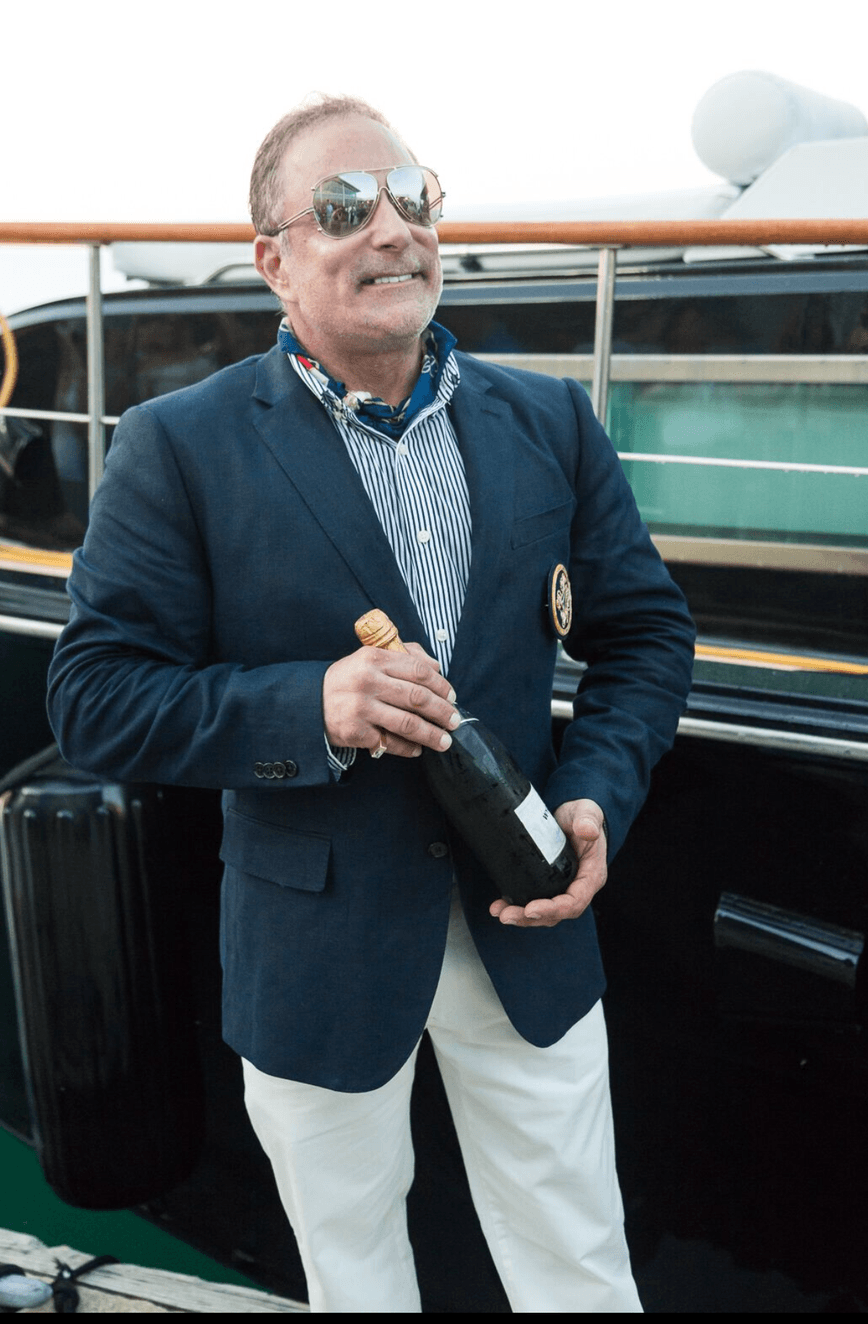 A man in a suit is holding a bottle of champagne