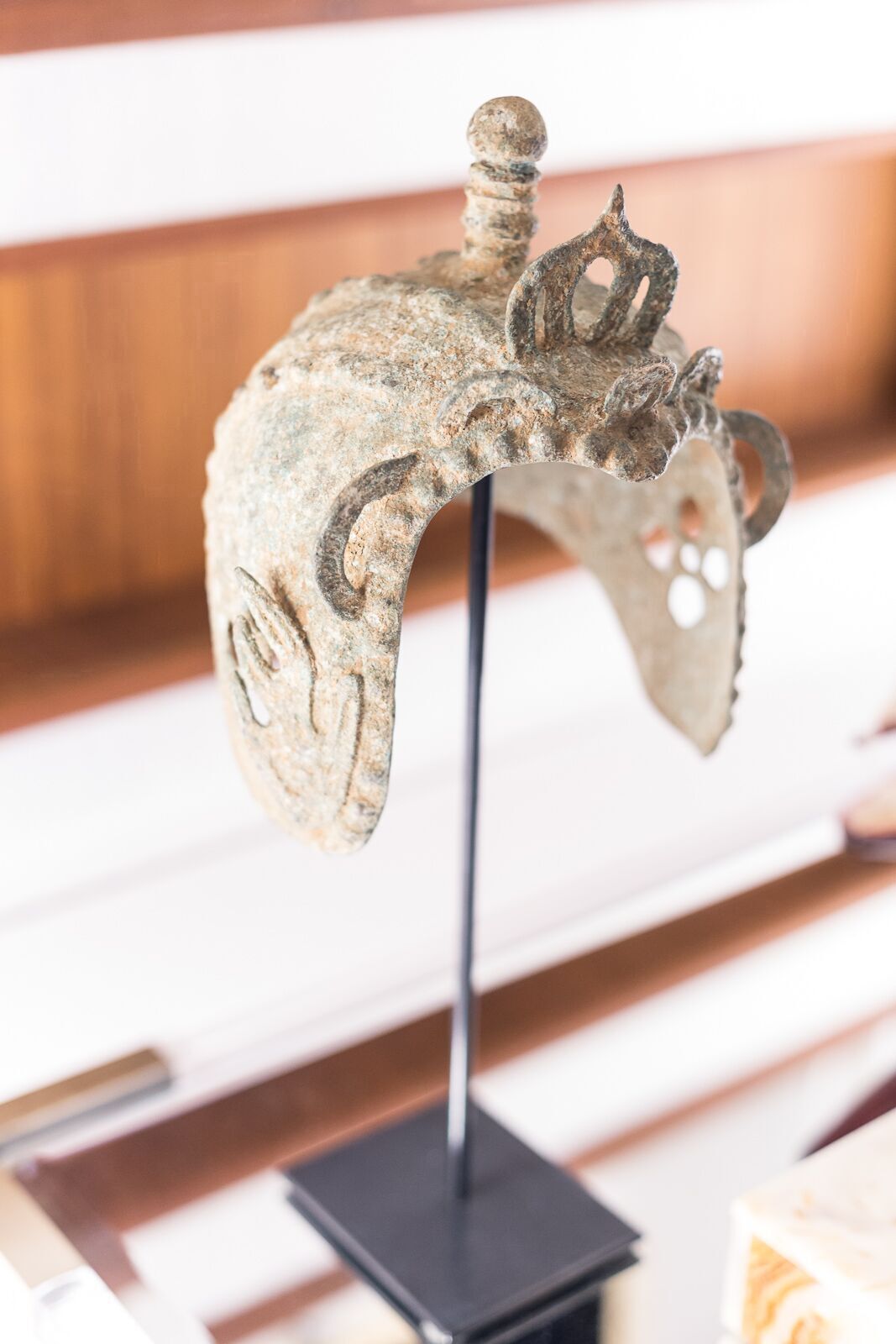 A statue of a helmet on a stand on a table