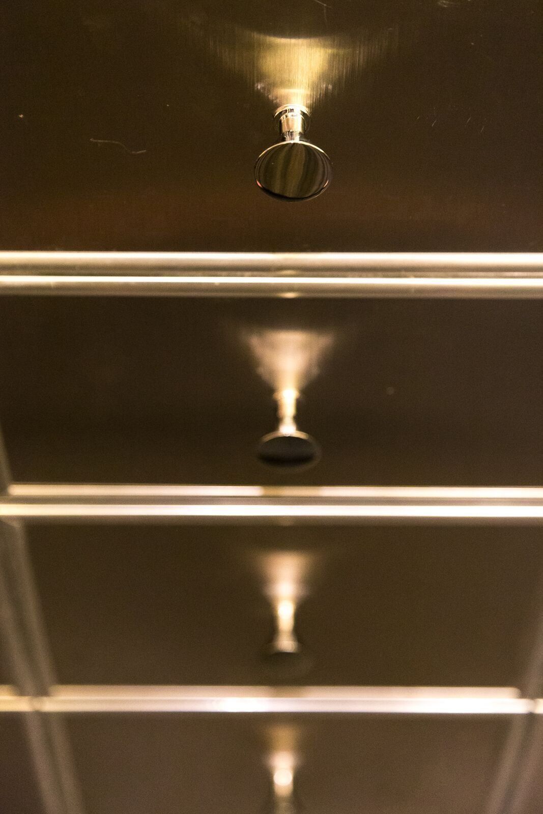 A close up of a stainless steel refrigerator door with a light shining on it.