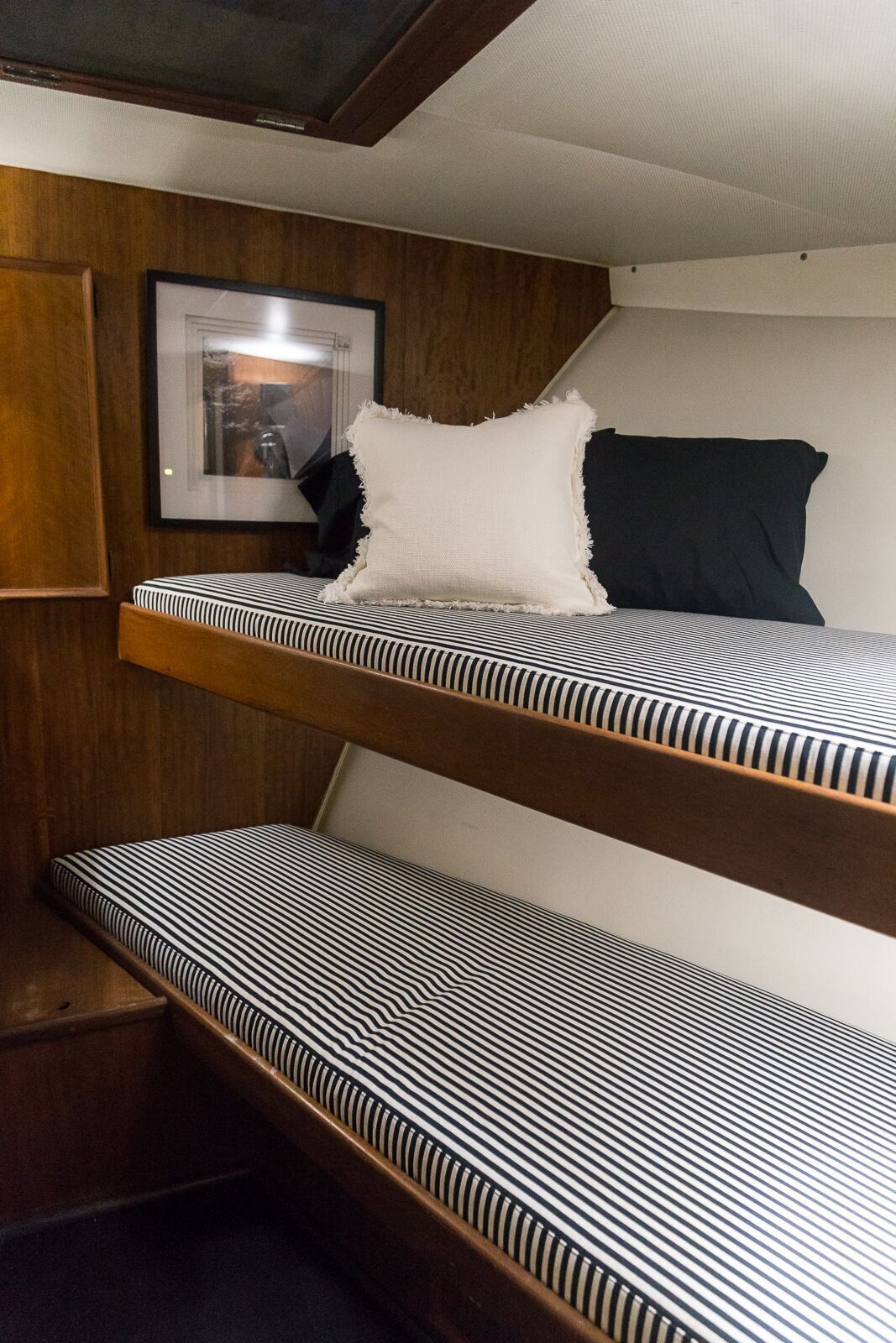 Two bunk beds on a boat with black and white striped sheets