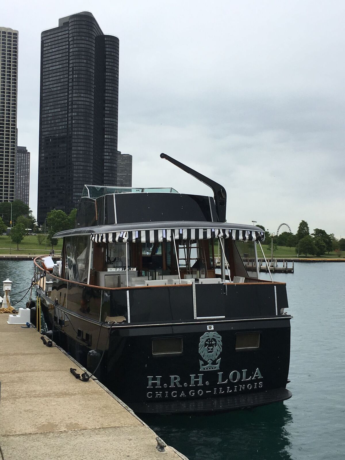A boat named h.r.h. lola is docked at a dock