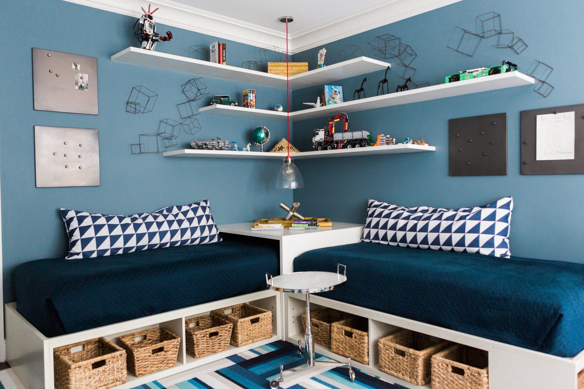 A bedroom with two beds , shelves and baskets.