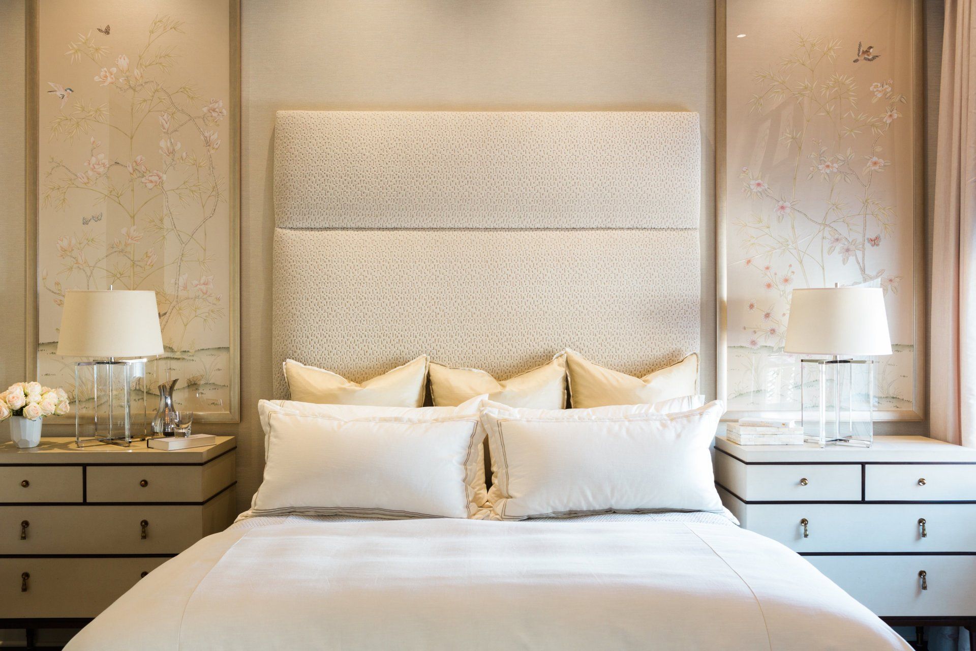 A bedroom with a bed , nightstands , and lamps.