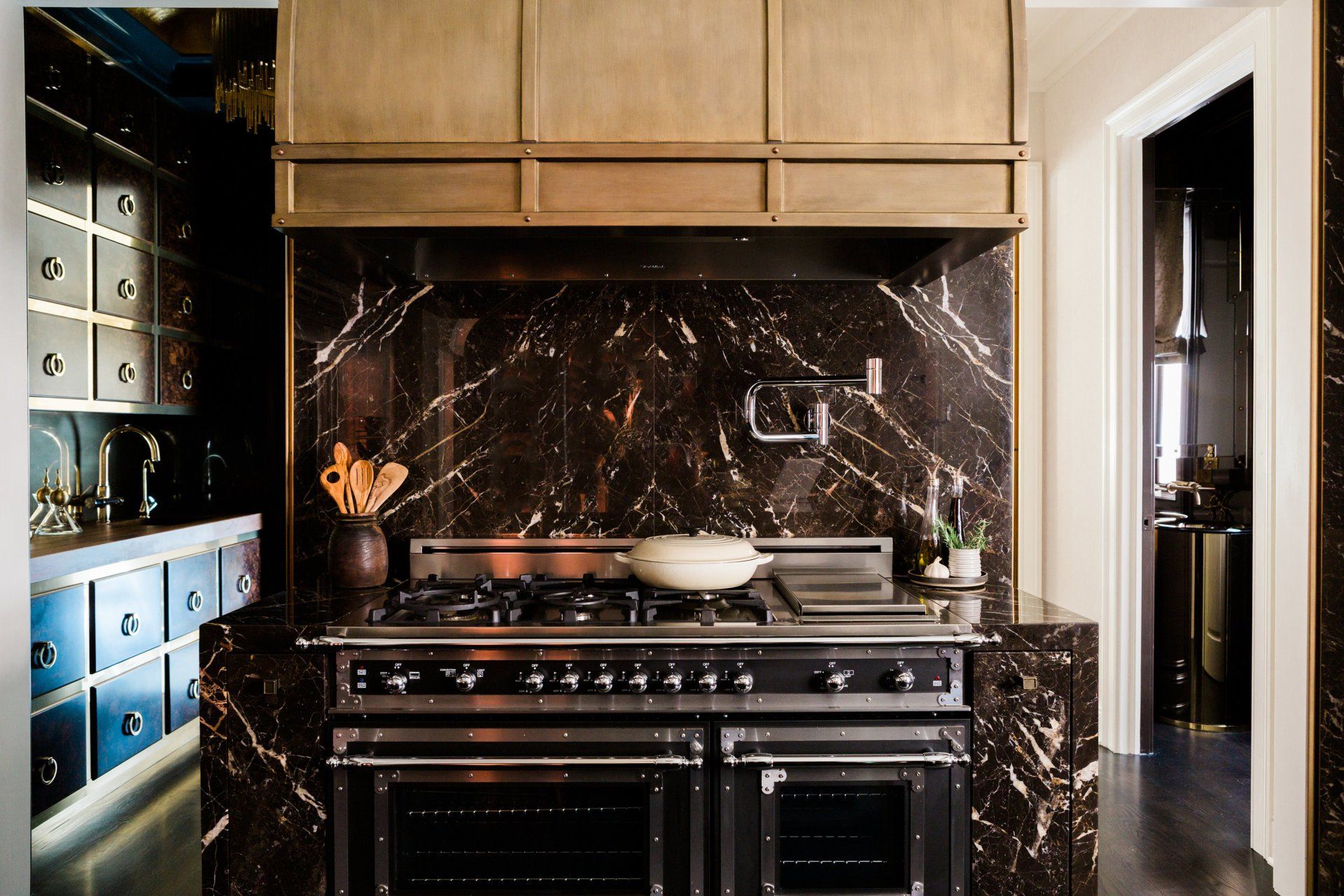 A kitchen with a stove top oven and marble counter tops