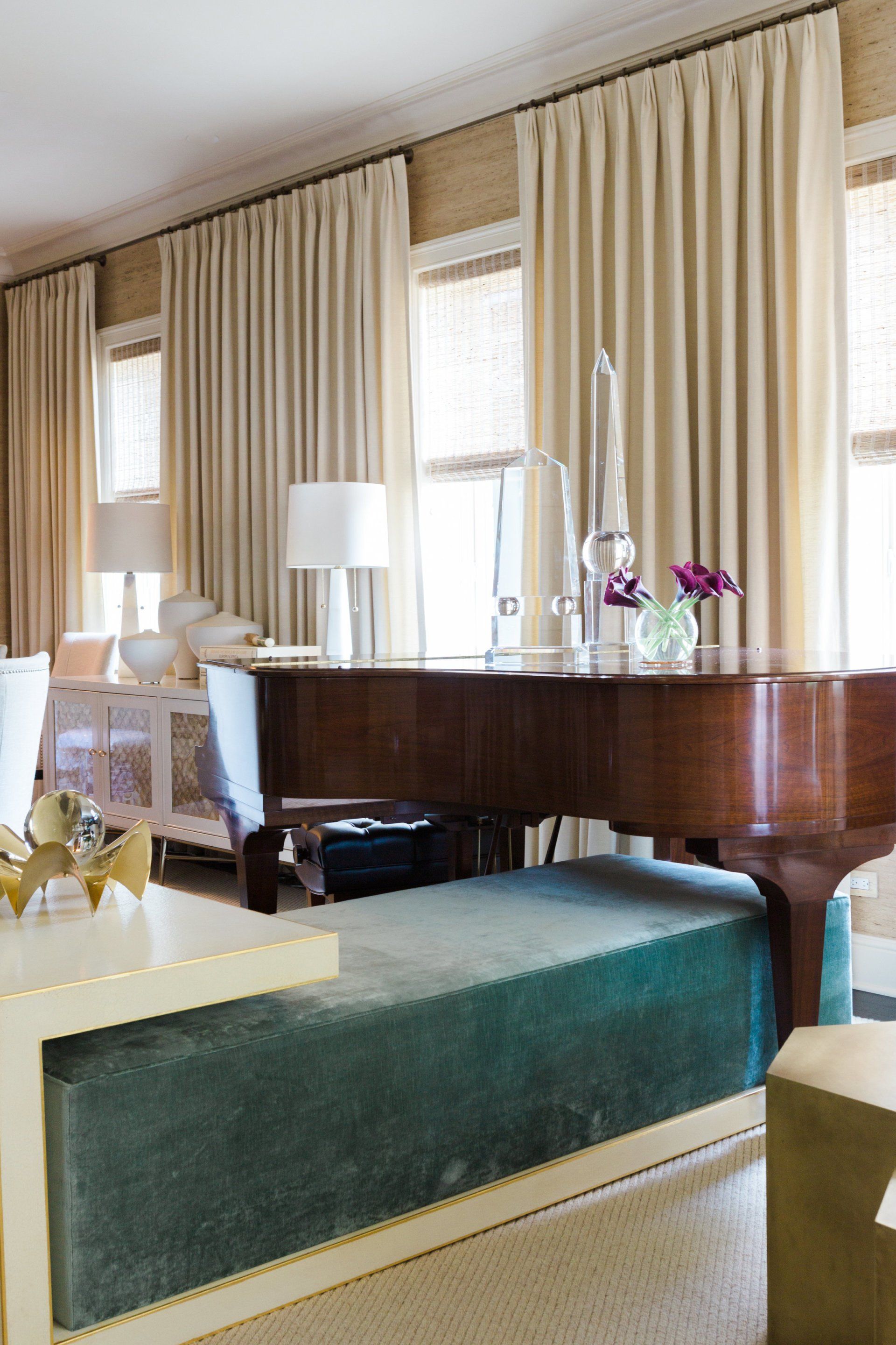 A living room with a piano and a green bench