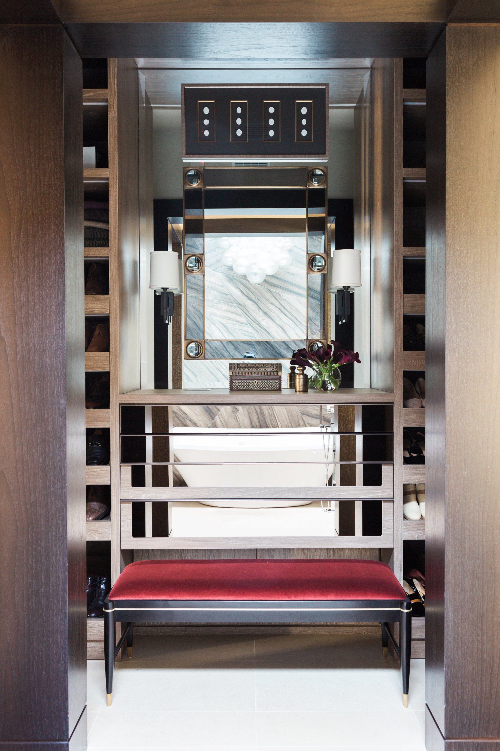 A bathroom with a red bench and a mirror
