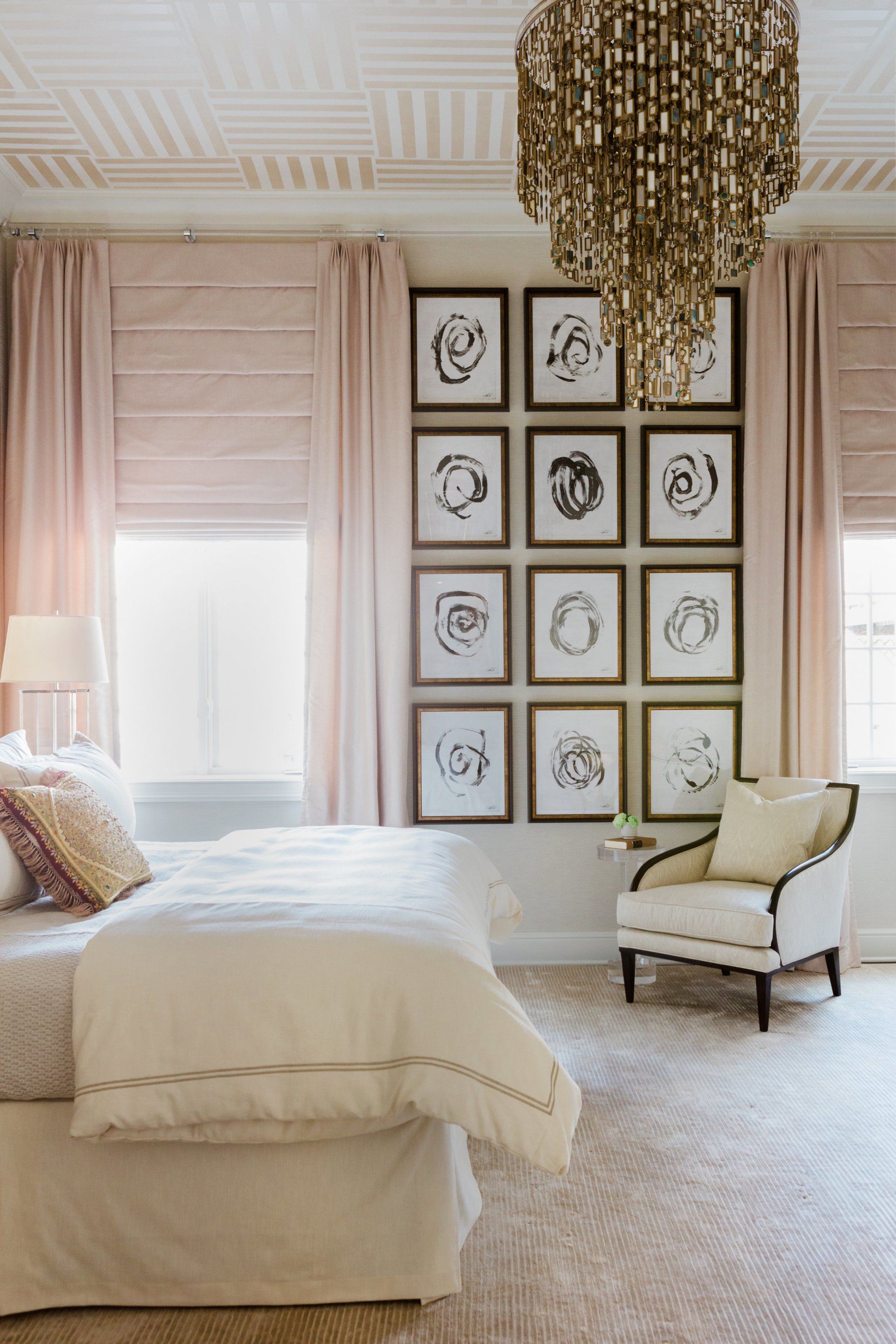 A bedroom with a bed , chair , and chandelier.