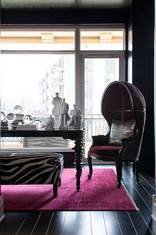A room with a zebra print ottoman and a chair