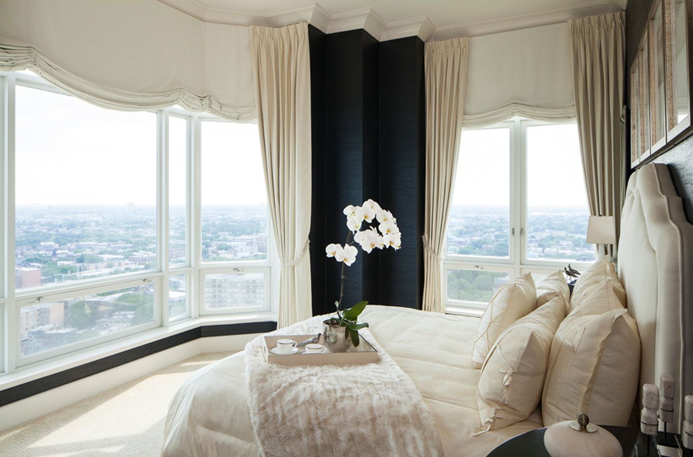 A bedroom with a large bed and lots of windows