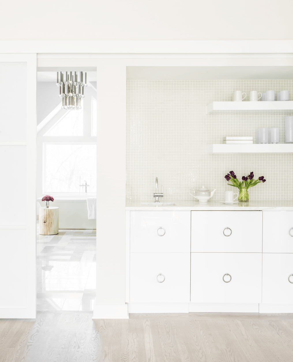 A white room with a sliding glass door leading to a bathroom