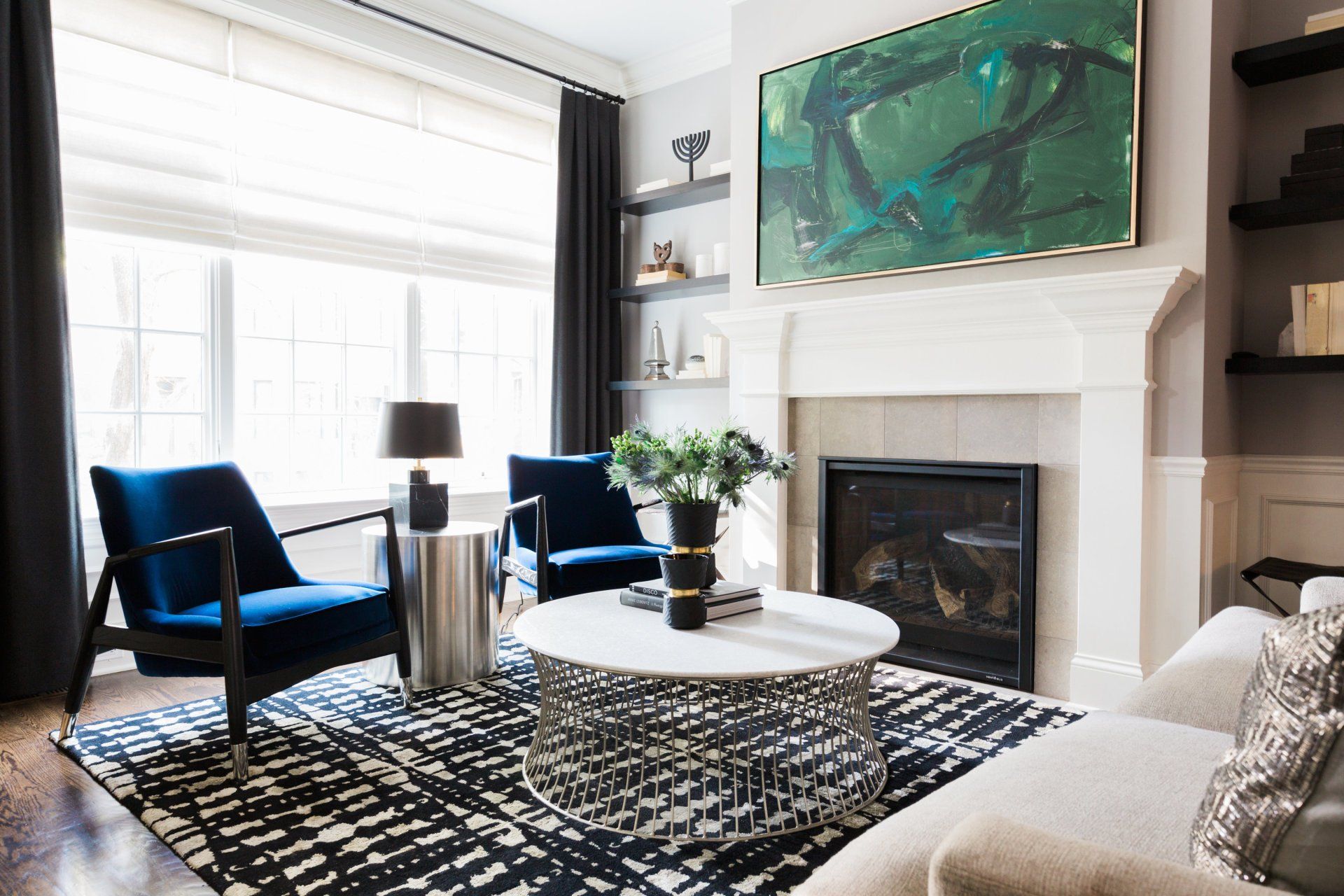A living room with a couch , chairs , coffee table and fireplace.