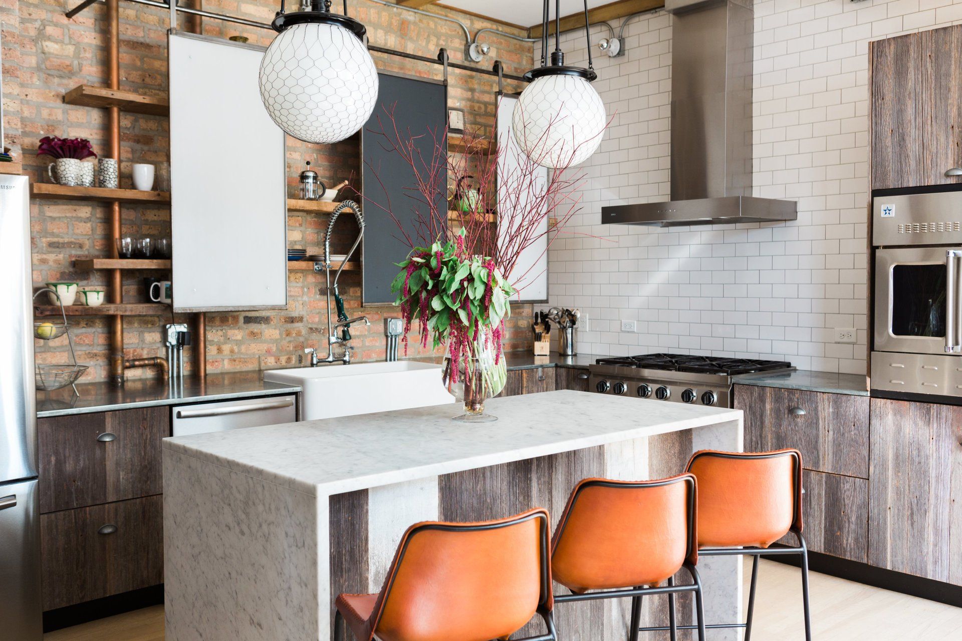 A kitchen with stainless steel appliances , wooden cabinets , and a large island.