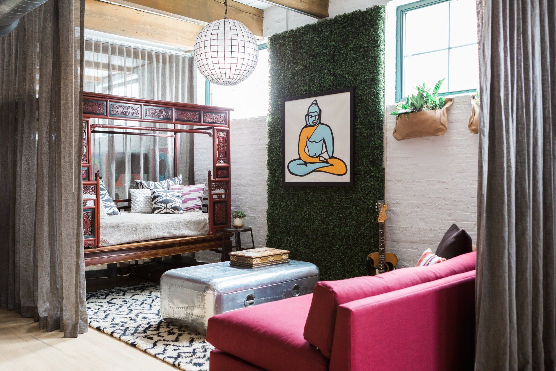 A living room with a pink couch and a bed.