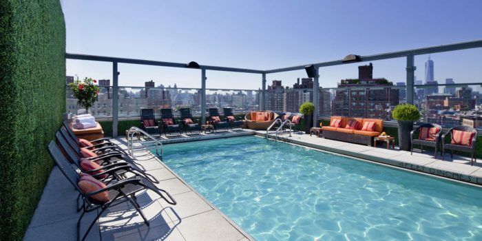 There is a large swimming pool on the roof of a building.