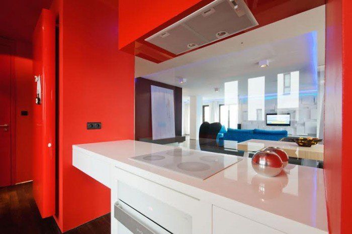 A kitchen with red walls and a white counter top