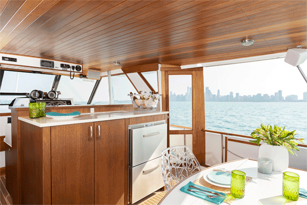 A kitchen and dining area on a boat with a view of the ocean