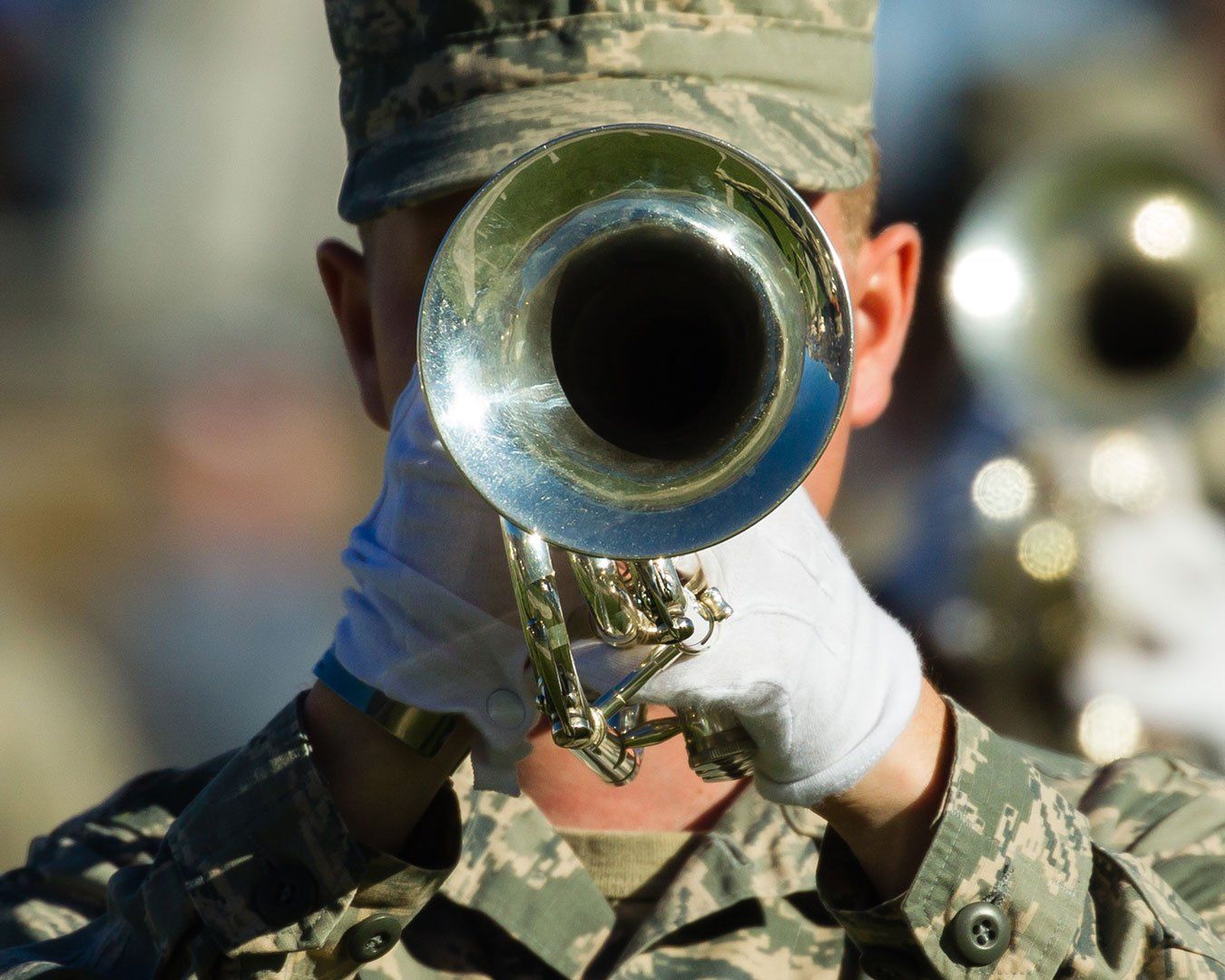 Person in military uniform playing a trumpet.