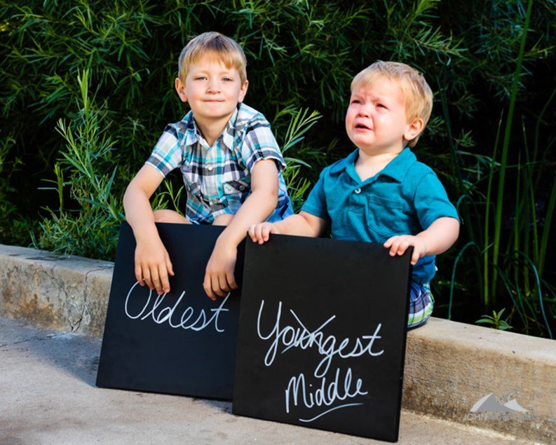 Two boys with chalkboards, one labeled 