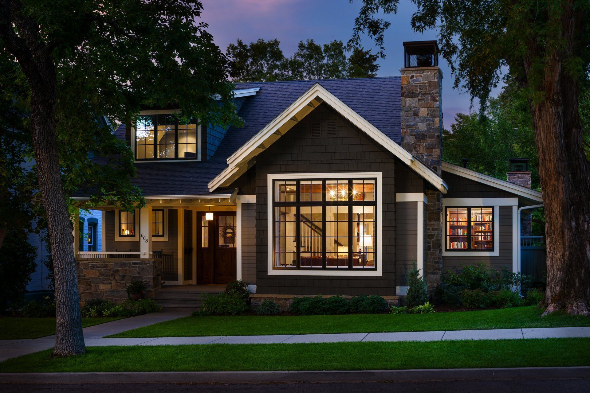 A large house with a lot of windows is lit up at night.