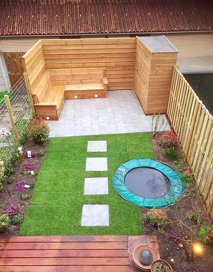 Kleine achtertuin met houten zitgedeelte, gazon, stapstenen en een siervijver.