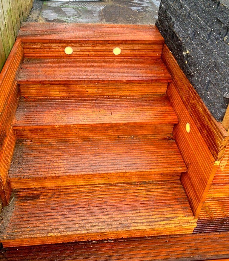 Houten buitentrap met ingebouwde verlichting, die naar boven leidt.