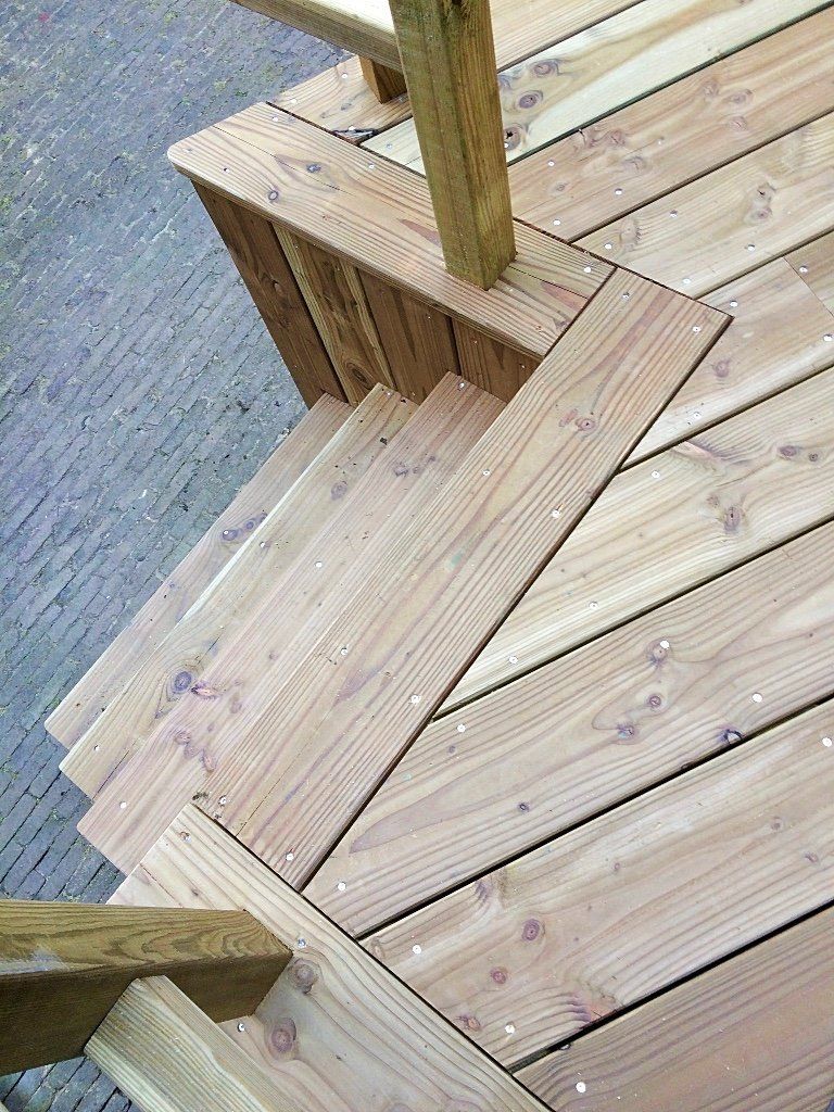 Houten buitentrap, schuin ontwerp, bevestigd aan een terras.