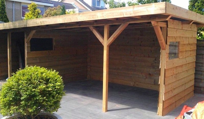 Houten carport met één draagbalk, gebouwd in een achtertuin.