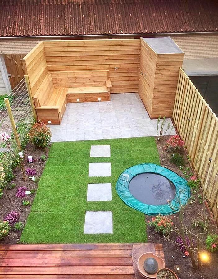 Kleine achtertuin met houten zitgedeelte, stapstenen, een kleine vijver en gras.