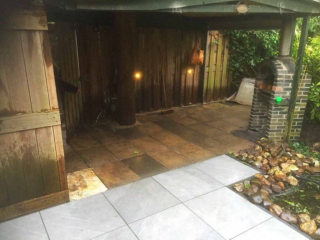 Houten schuuringang met stenen pad, bruine houten muren en kleine lampjes.