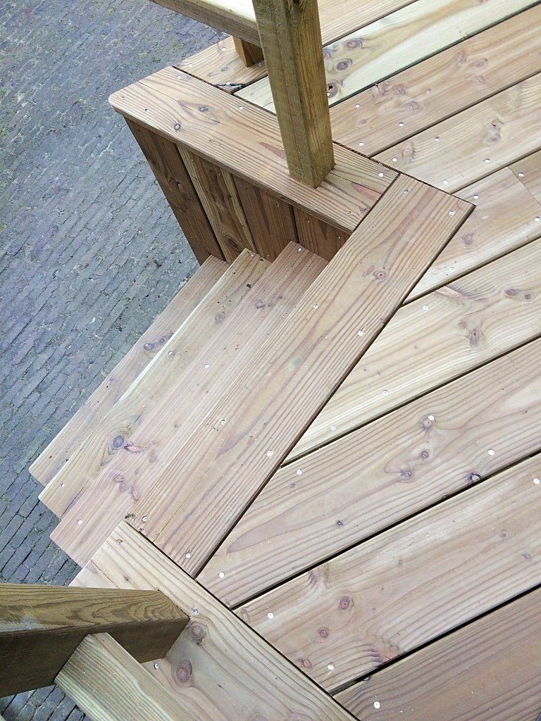 Houten terras met een trap naar beneden.