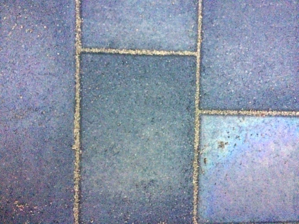 Blauwe bakstenen bestrating met witte voegen.