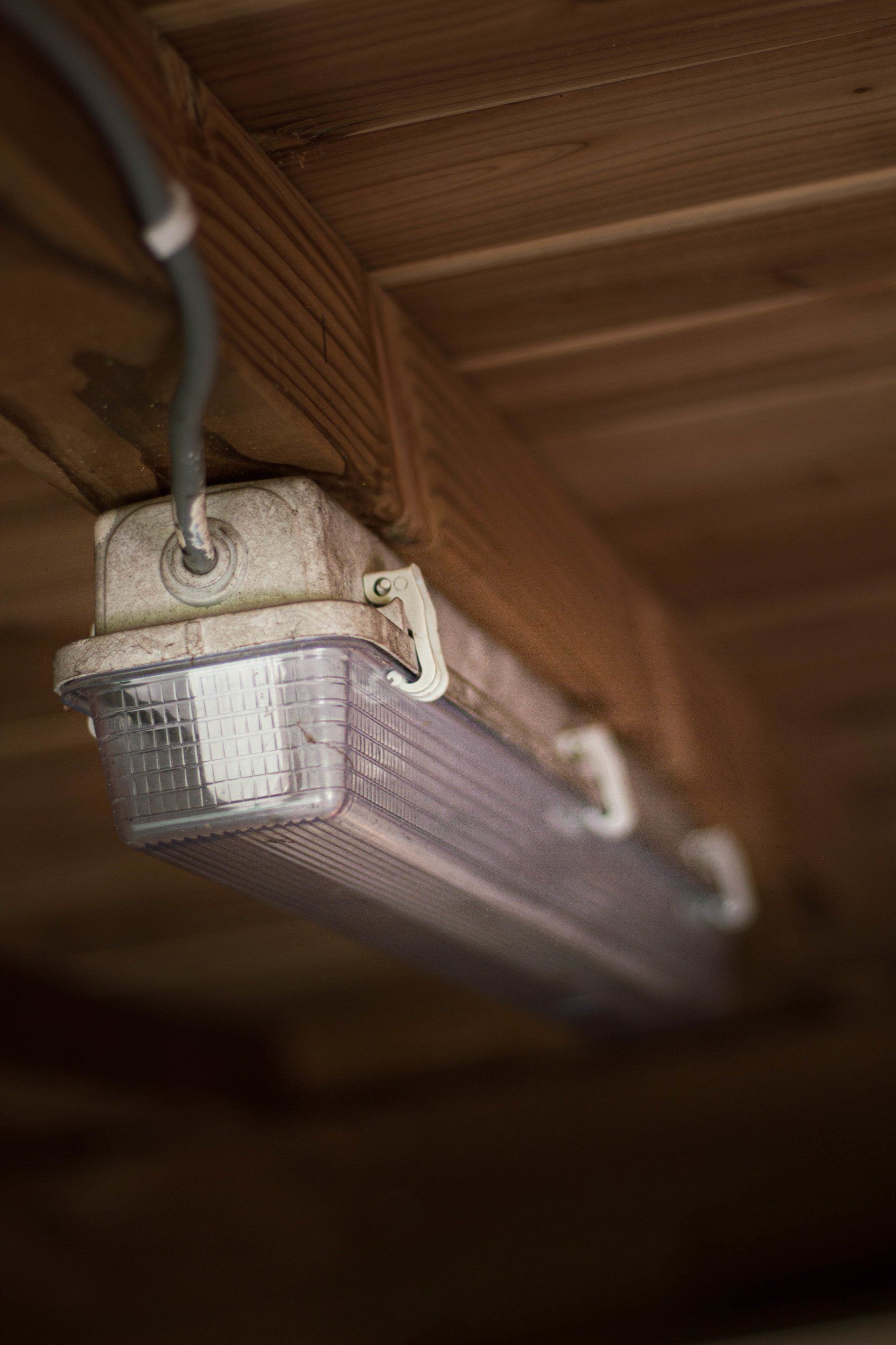 Een TL-armatuur is bevestigd aan een houten plafond.