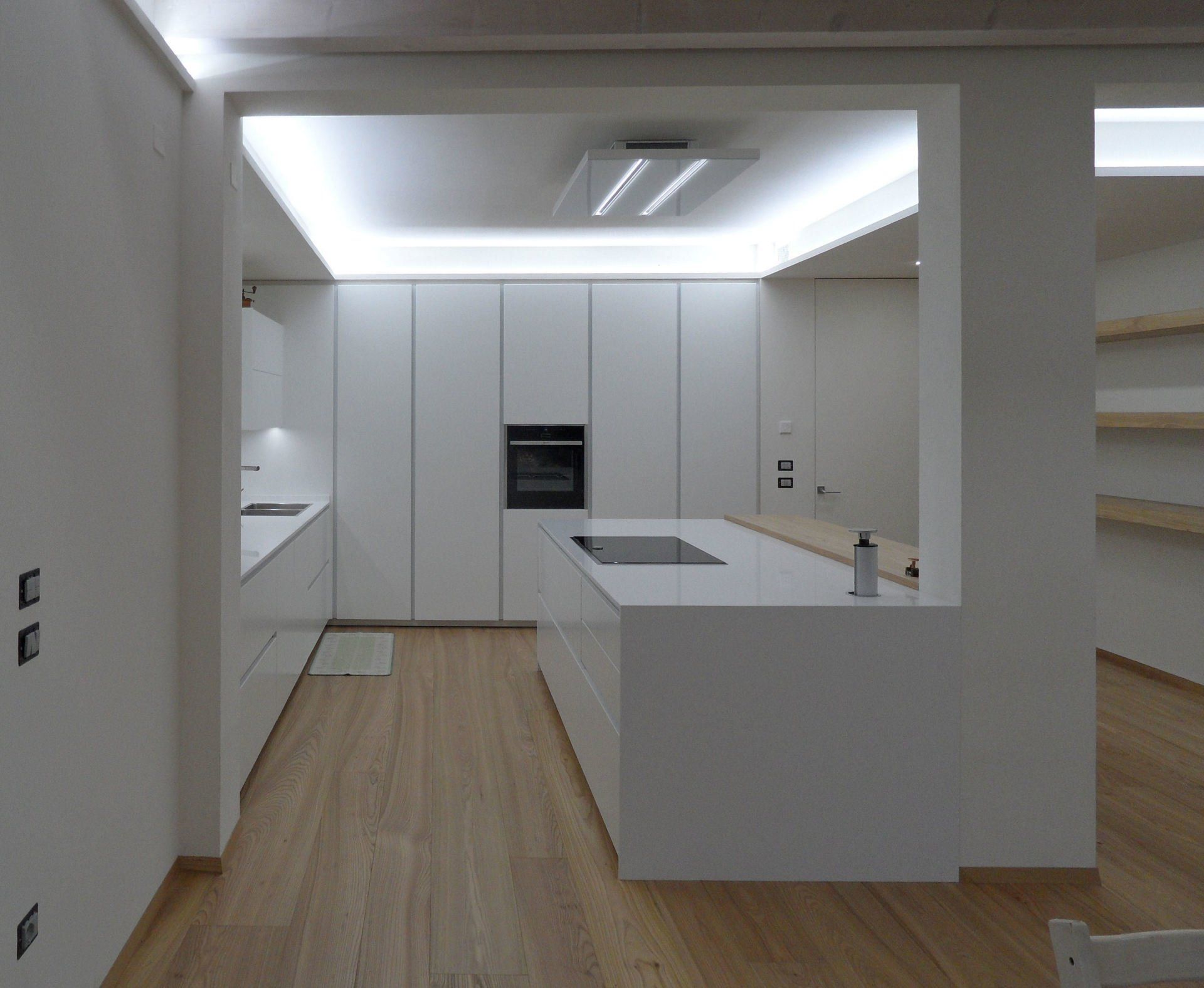 Ambiente cucina con ante maniglia gola e colonne a tutta altezza a soffitto