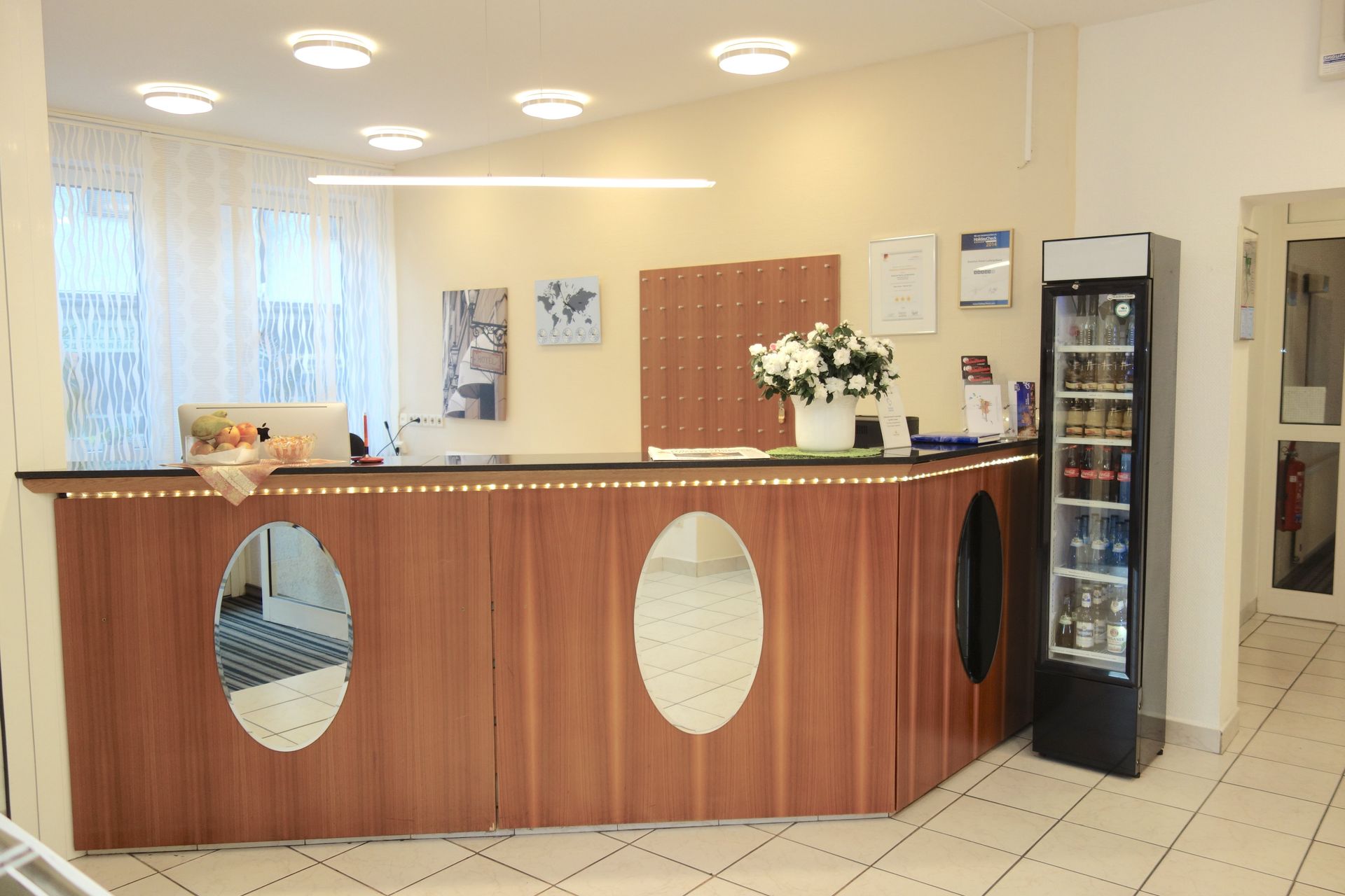 A hotel lobby with a wooden counter and a fridge