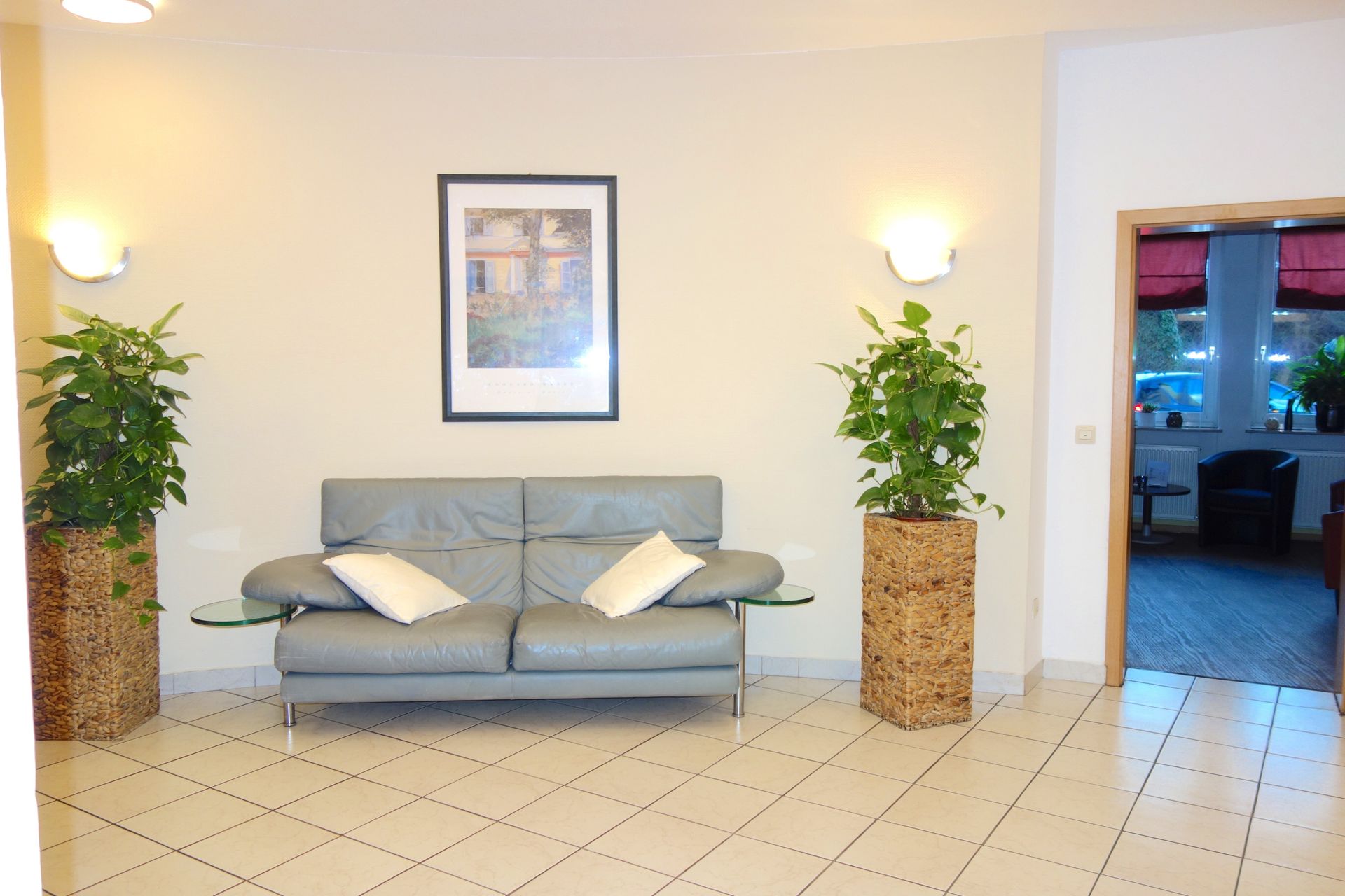 A living room with a couch and two potted plants