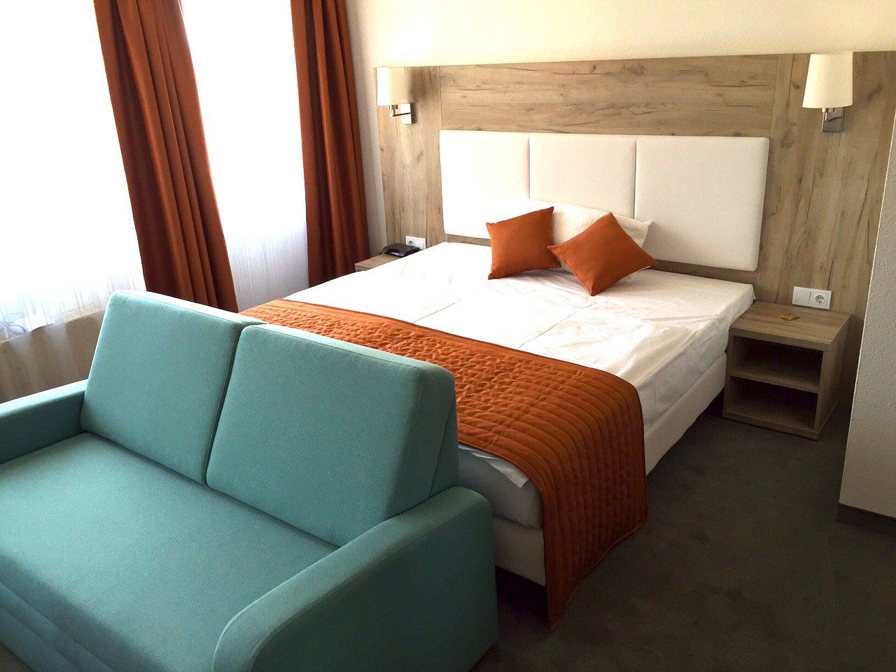 A hotel room with a bed and a couch
