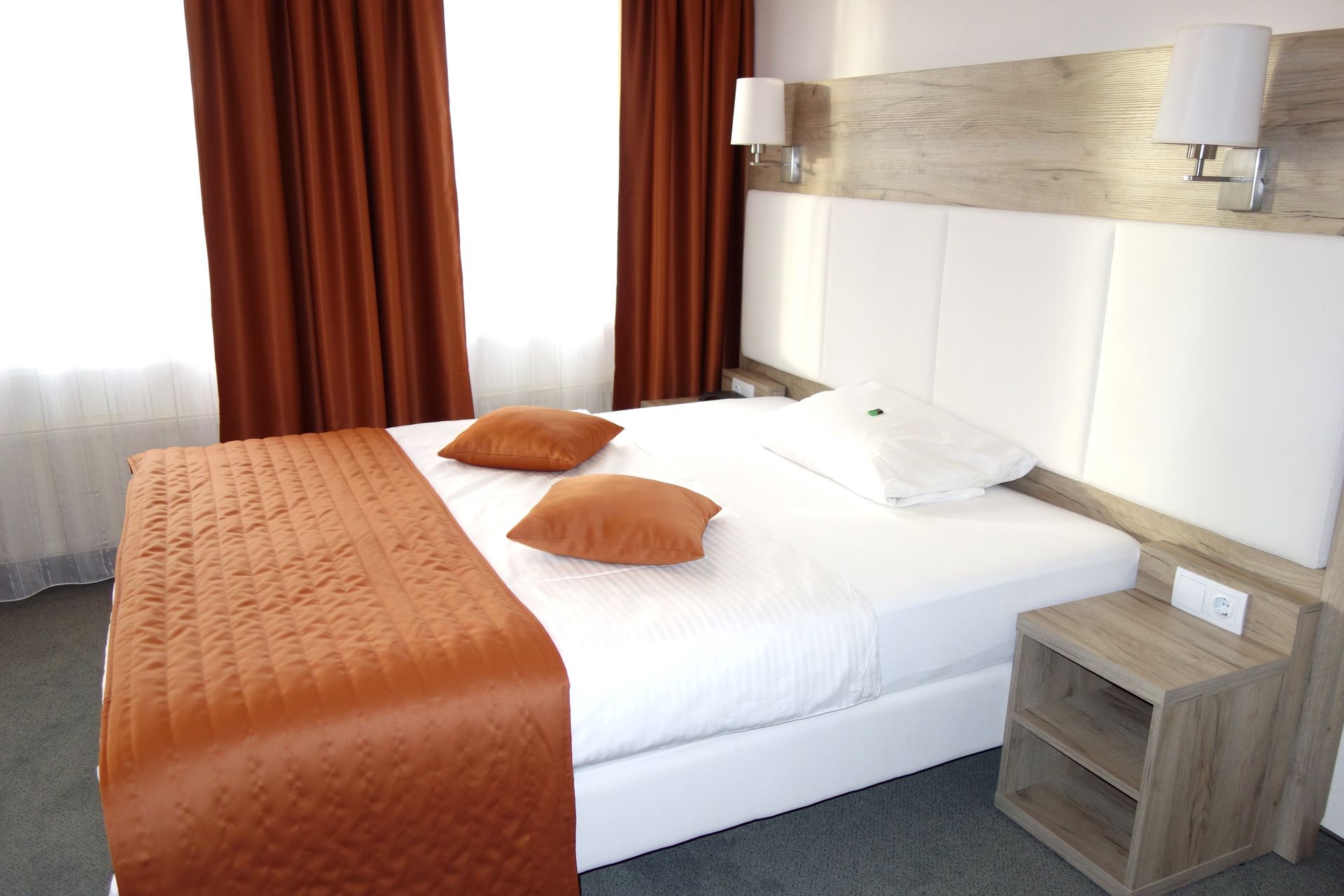 A hotel room with a bed and a nightstand