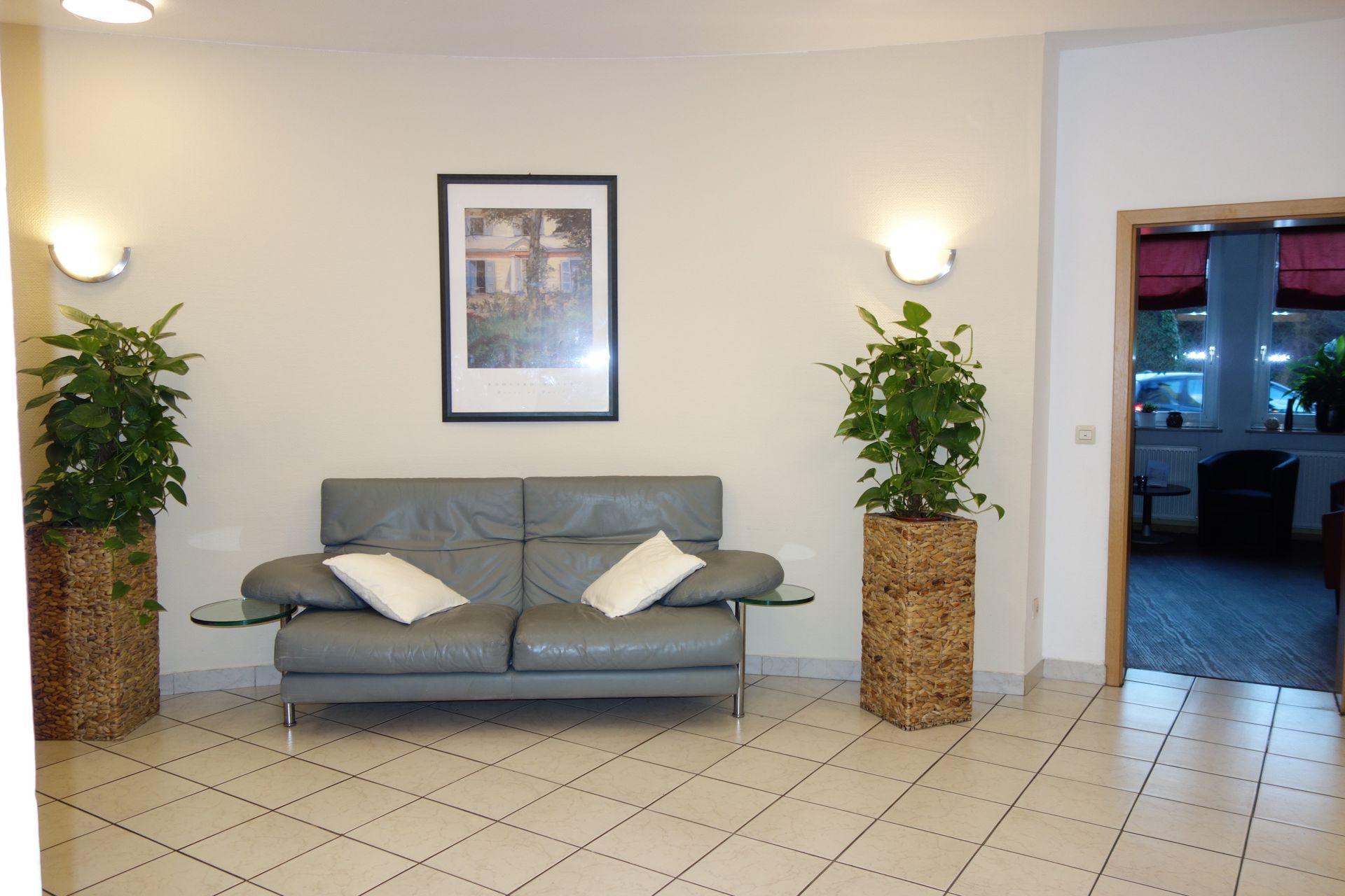A living room with a couch and two potted plants