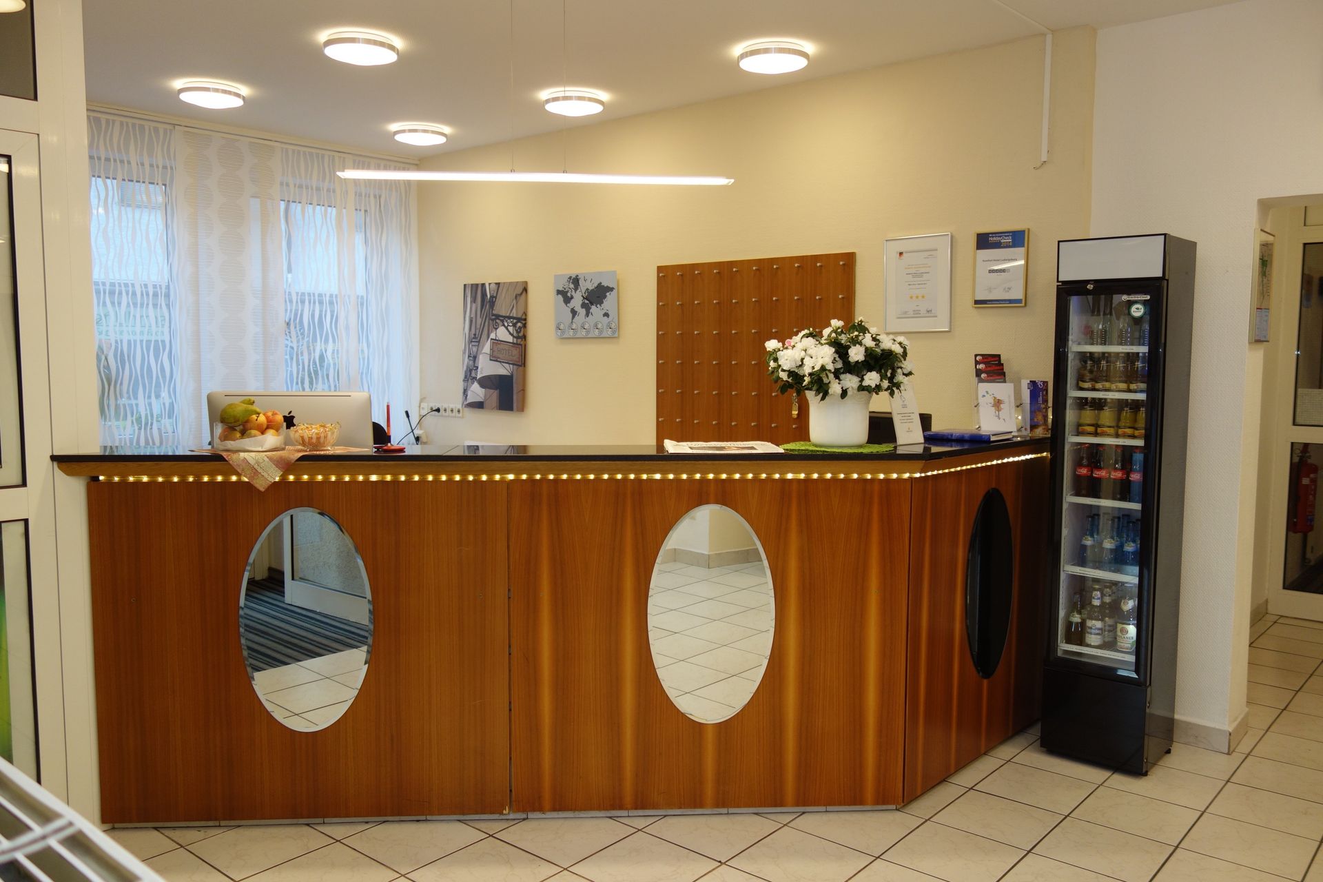 A hotel lobby with a wooden counter and a cooler